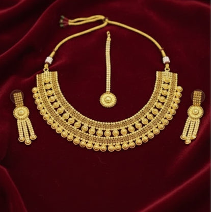 Traditional bridal gold-plated Kundan necklace set with matching earrings and maang tikka displayed on red velvet stand.