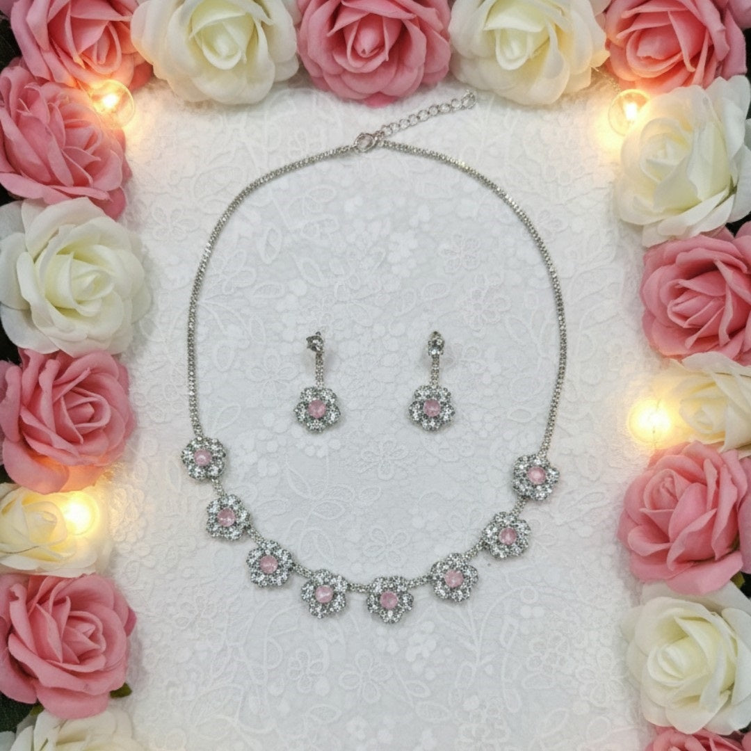 Silver floral necklace and matching earrings set with sparkling round crystals displayed on a red velvet jewelry stand, perfect for weddings and festive occasions.