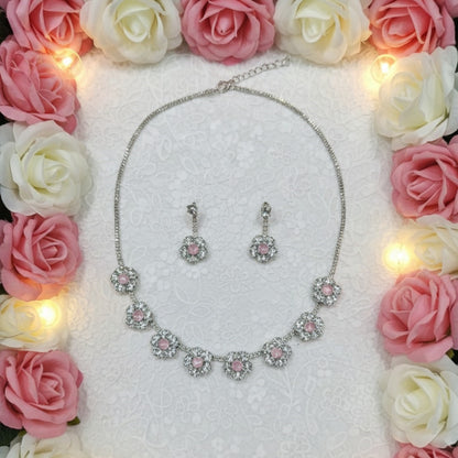 Silver floral necklace and matching earrings set with sparkling round crystals displayed on a red velvet jewelry stand, perfect for weddings and festive occasions.
