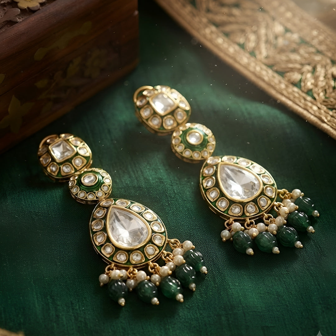 Green Kundan Polki drop earrings with gold finish, pearl clusters, carved green bead tassels, and traditional Indian bridal design.