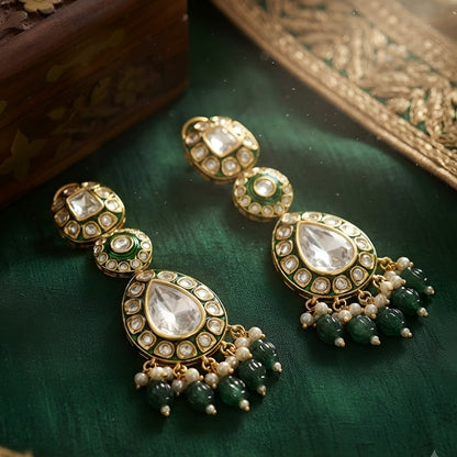 Green Kundan Polki drop earrings with gold finish, pearl clusters, carved green bead tassels, and traditional Indian bridal design.