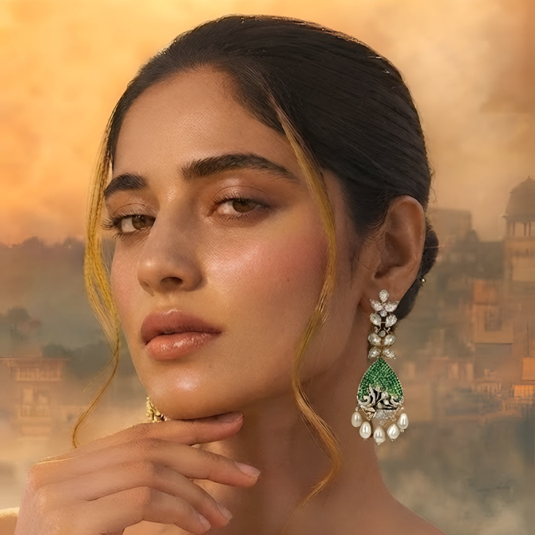 Luxury gold-plated teardrop earrings with emerald green stones, sparkling American diamonds, and pearl drop danglers for women.