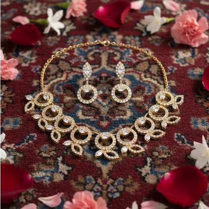 "Gold-tone necklace and earring set with circular and leaf motifs displayed on black velvet stand"
