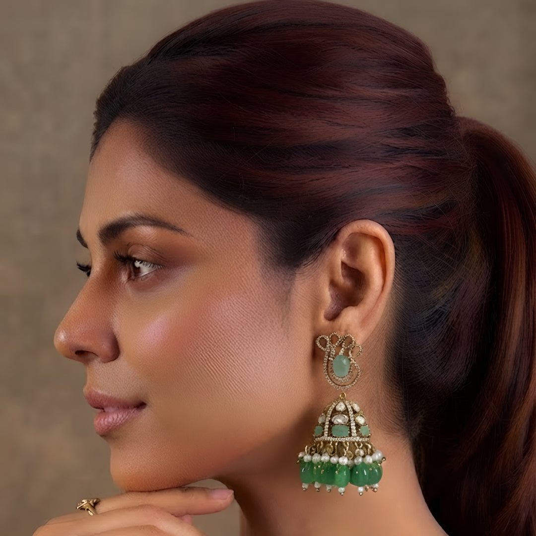 Antique gold Kundan jhumka earrings featuring aqua green stones, pearl accents, and green bead drops for women.