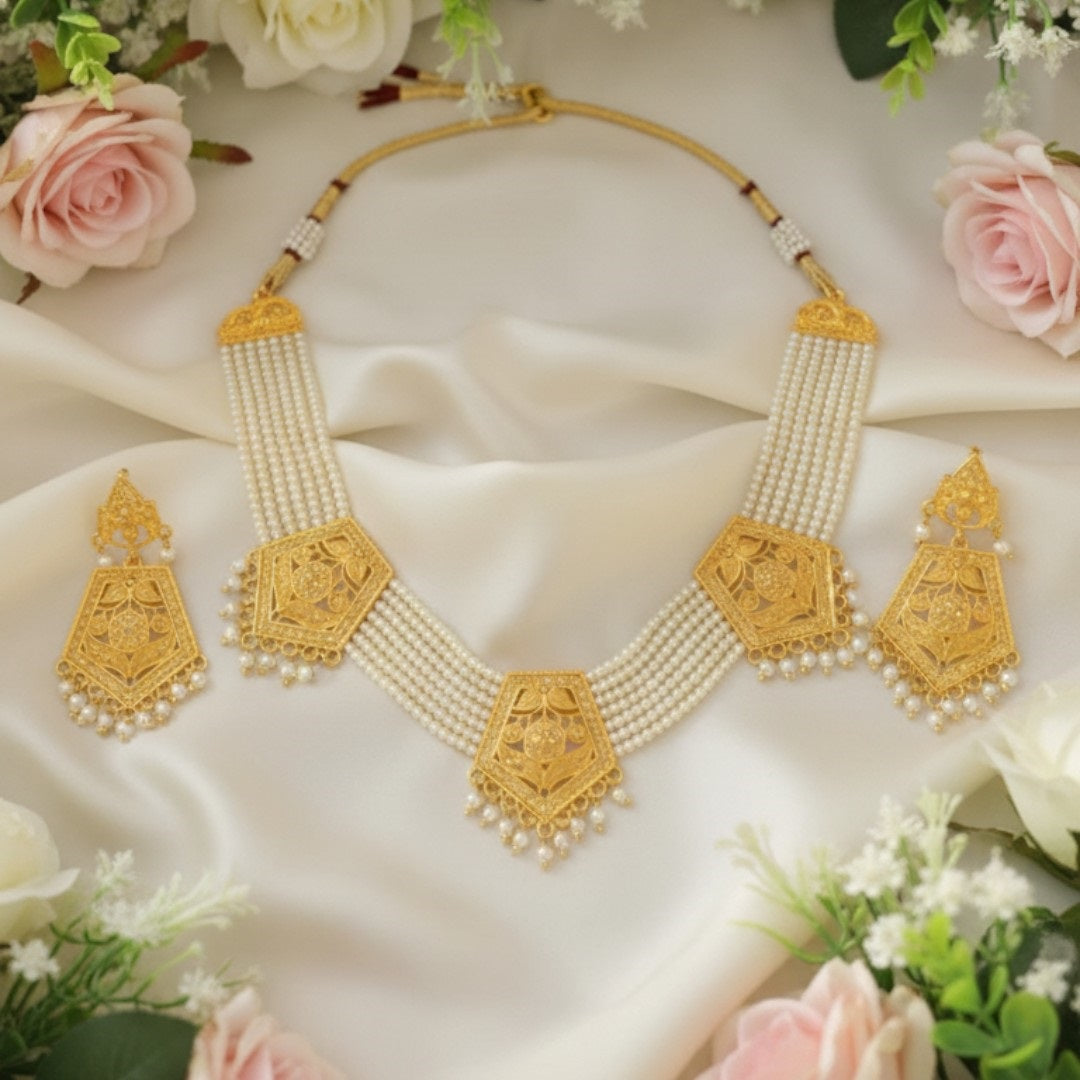 Temple-style gold plated necklace set with long matching earrings on red display stand