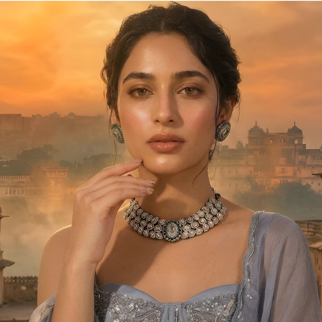 Elegant diamond and emerald choker necklace set with matching stud earrings featuring intricate floral motifs, sparkling white stones, green gemstone accents, and a luxurious gold-tone finish.