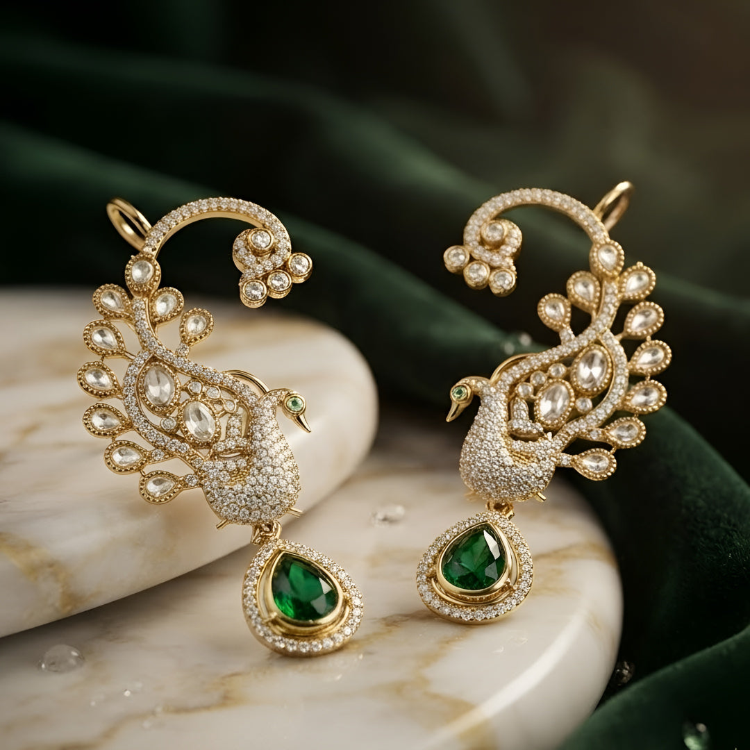 Luxury gold-plated peacock ear cuff earrings with Kundan Polki stones, sparkling CZ detailing, and emerald green teardrop crystal pendant for bridal and festive wear.