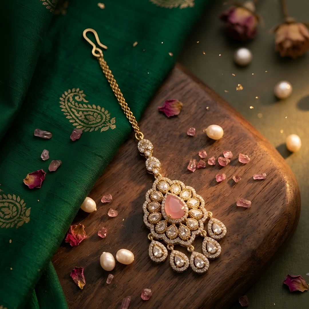 Gold plated pink stone Kundan maang tikka with Polki-inspired white stones and dangling charms for bridal wedding and festive wear.