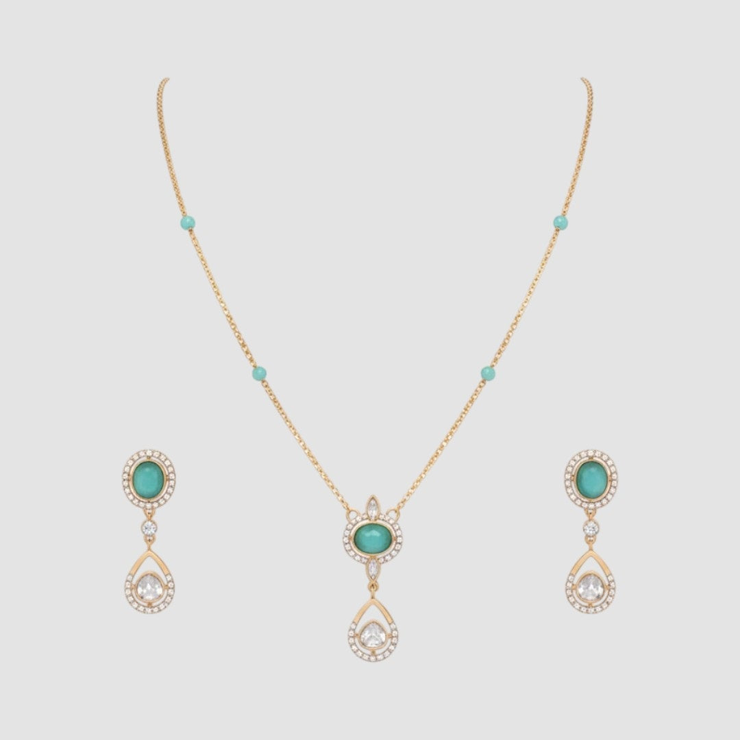 “Gold-plated necklace and matching earrings set with turquoise stones and crystal-accented teardrop pendants.”