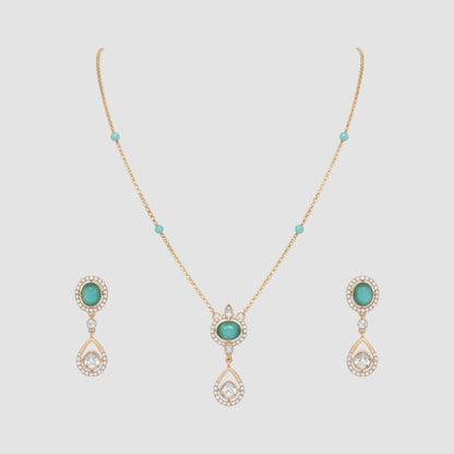 “Gold-plated necklace and matching earrings set with turquoise stones and crystal-accented teardrop pendants.”
