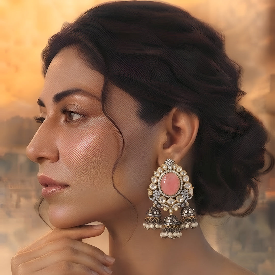 Pink Kundan jhumka earrings with antique gold finish, oval pink stone, sparkling Kundan crystals, and pearl tassel drops for bridal and festive wear.