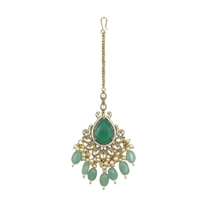 Gold-tone bridal maang tikka featuring a pear-shaped green stone, crystal floral detailing, pearl accents, and green bead drops for traditional Indian wedding jewelry.