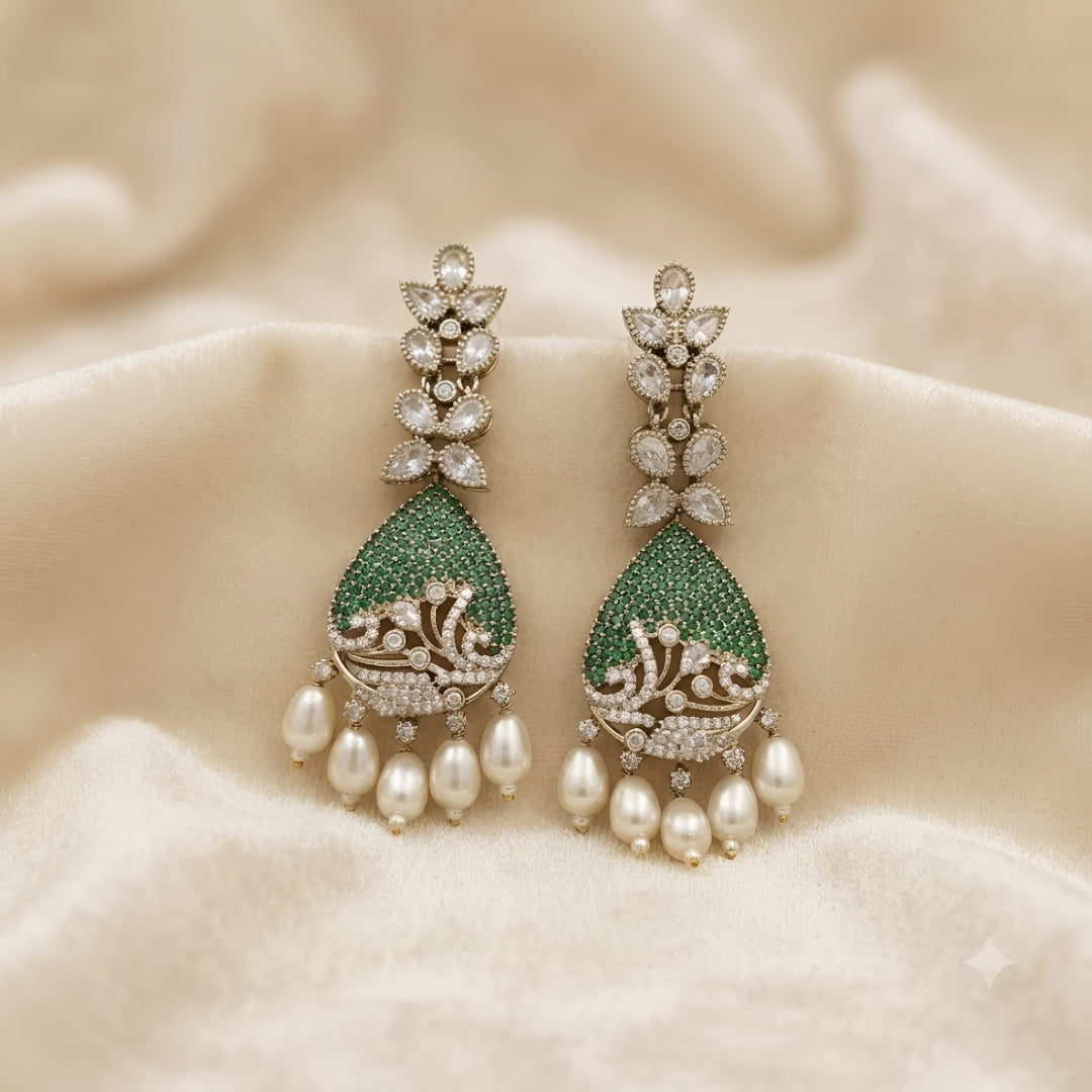 Luxury gold-plated teardrop earrings with emerald green stones, sparkling American diamonds, and pearl drop danglers for women.
