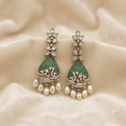 Luxury gold-plated teardrop earrings with emerald green stones, sparkling American diamonds, and pearl drop danglers for women.