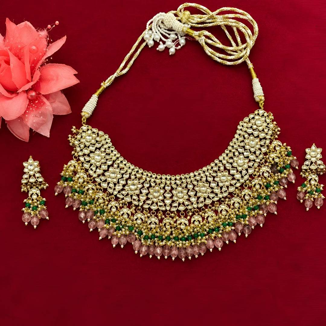 "Antique gold bib-style kundan necklace with matching floral earrings"