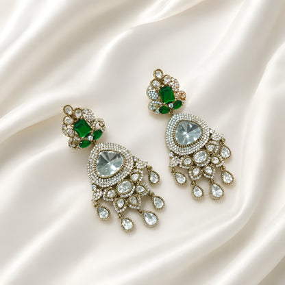 Luxury gold-plated statement earrings with emerald green stones, Kundan stones, sparkling American diamonds, and teardrop danglers for women.