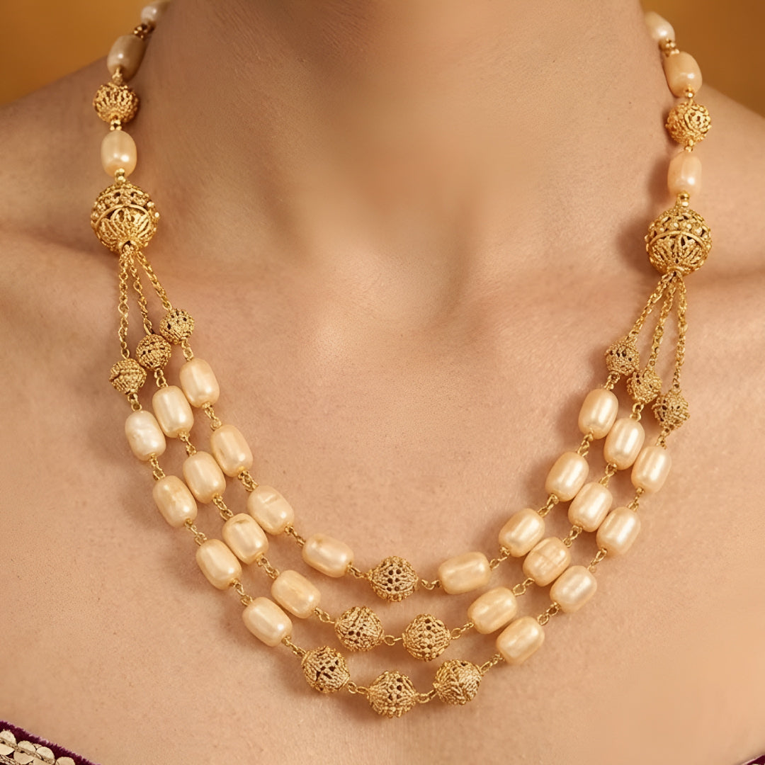 Elegant multi-layer ivory pearl beaded necklace set with gold-tone filigree accents and matching drop earrings for women.