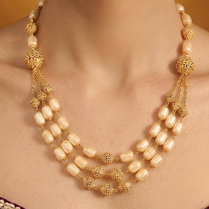 Elegant multi-layer ivory pearl beaded necklace set with gold-tone filigree accents and matching drop earrings for women.