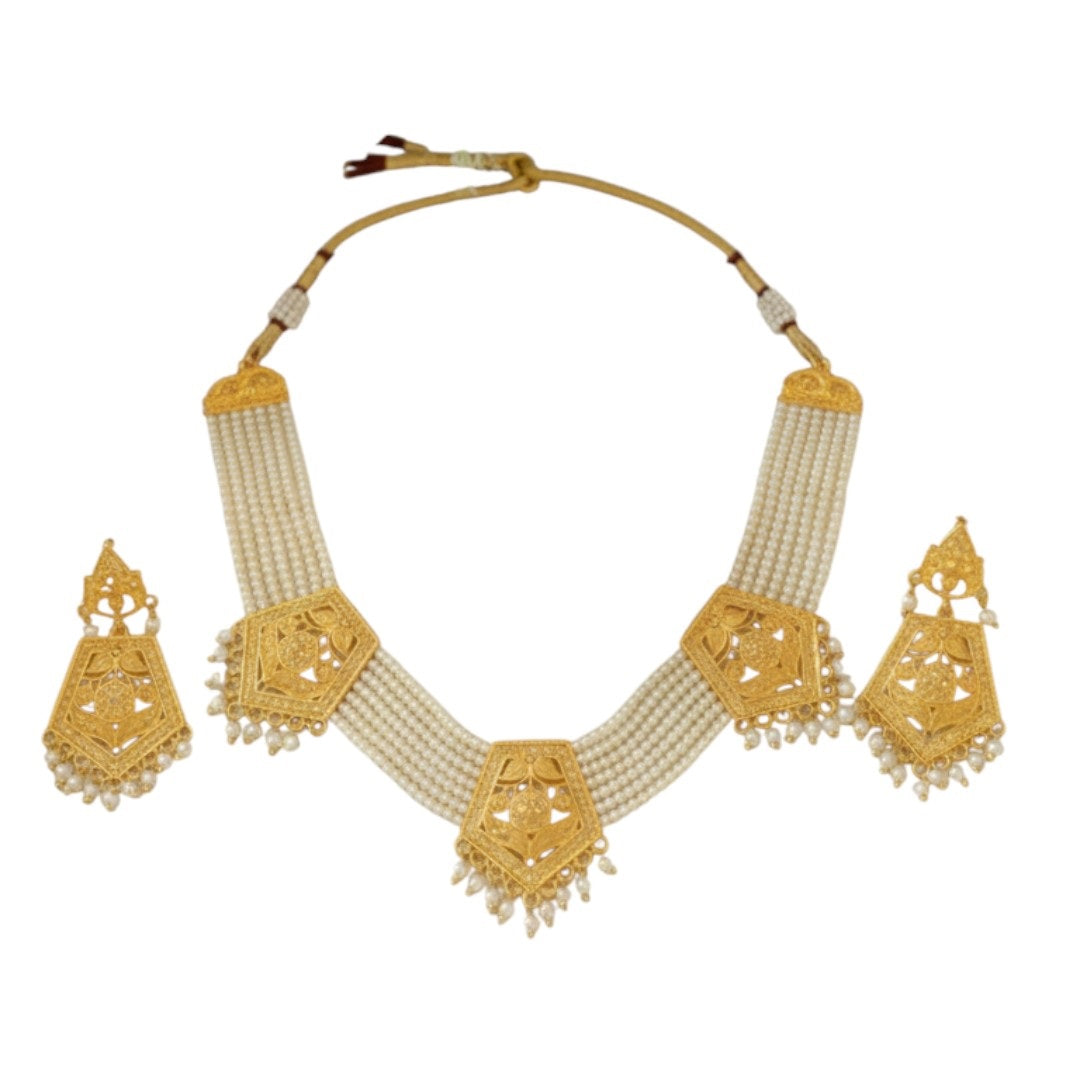Temple-style gold plated necklace set with long matching earrings on red display stand