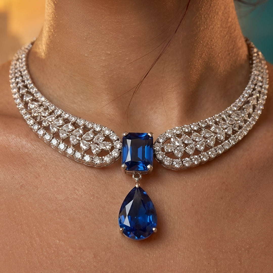 Elegant blue sapphire crystal choker necklace set with zircon-studded silver finish and matching drop earrings for women.