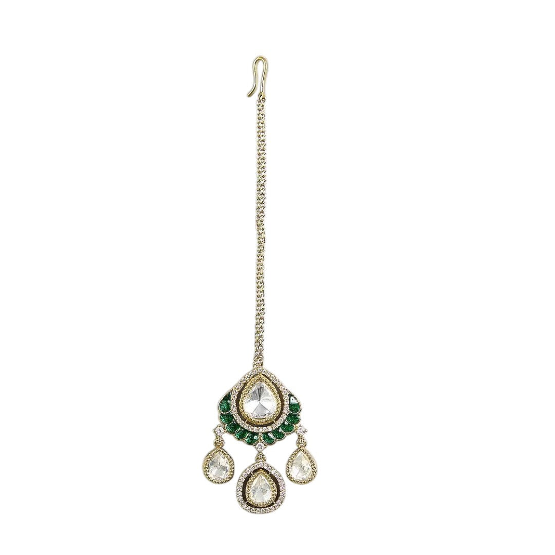 Gold-toned Kundan teardrop maang tikka with green stone detailing and three dangling teardrop charms for bridal and festive wear.