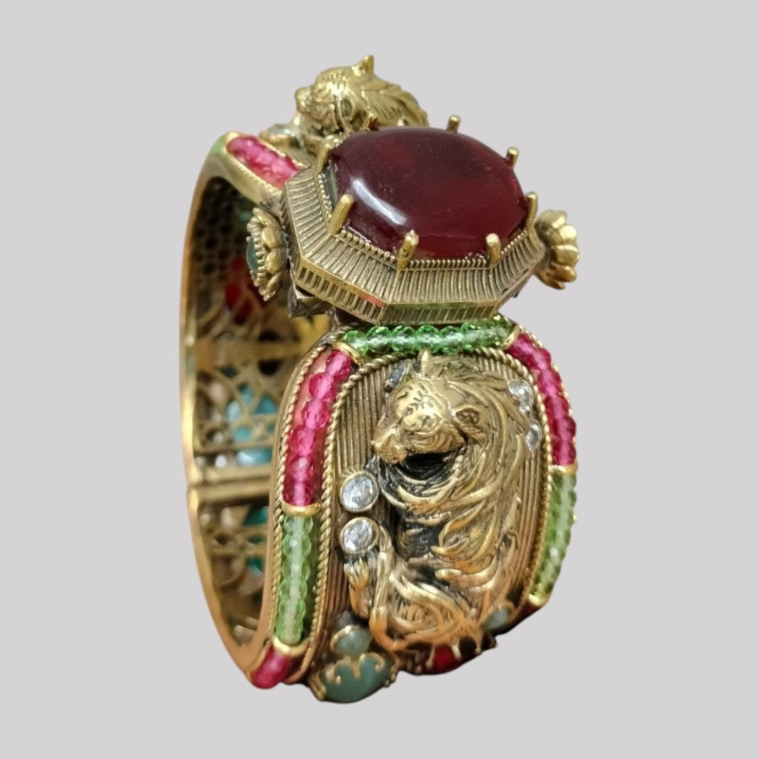 Antique gold-plated lion motif bangle with ruby centerpiece and colorful gemstones
