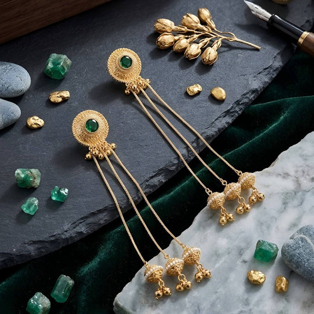 Traditional gold plated long chain tassel earrings with green stone stud and pearl jhumka drops for women, ideal for bridal, wedding, festive, and ethnic wear.