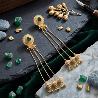 Traditional gold plated long chain tassel earrings with green stone stud and pearl jhumka drops for women, ideal for bridal, wedding, festive, and ethnic wear.