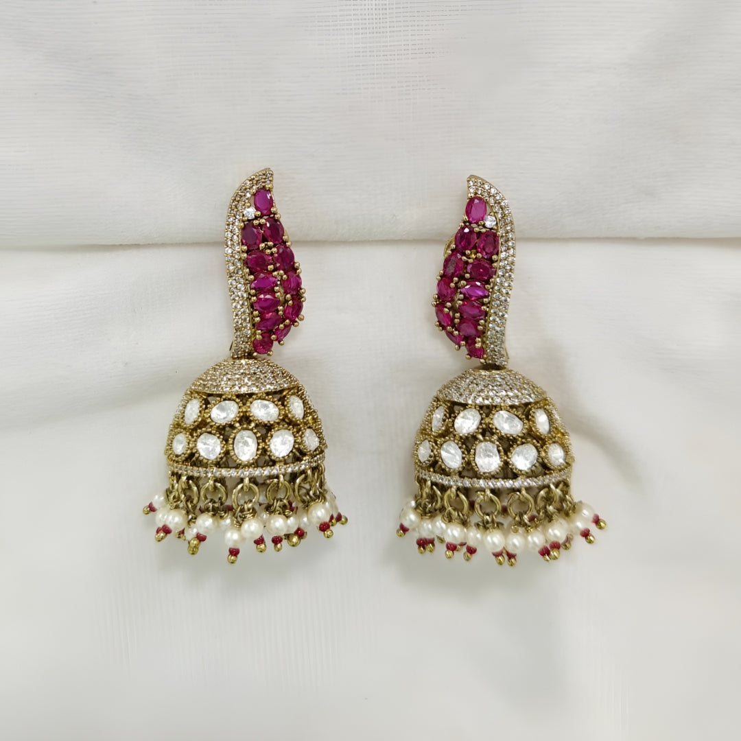 Antique gold Kundan jhumka earrings with ruby stones, sparkling American diamonds, and pearl drop fringe for women.