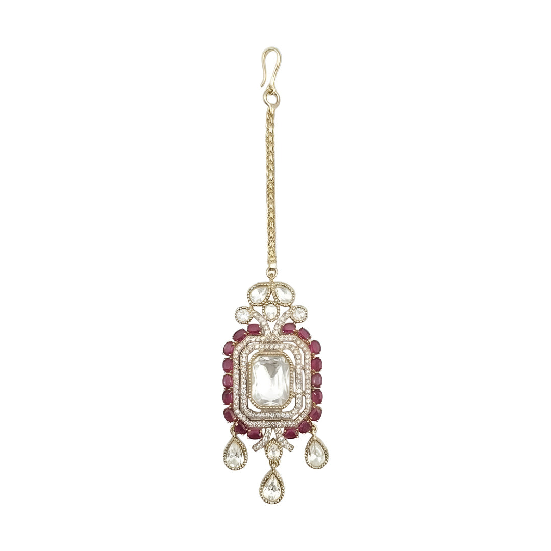 Gold-plated Kundan Maang Tikka featuring a rectangular white crystal centerpiece, ruby red stones, and elegant teardrop danglers for bridal and festive wear.