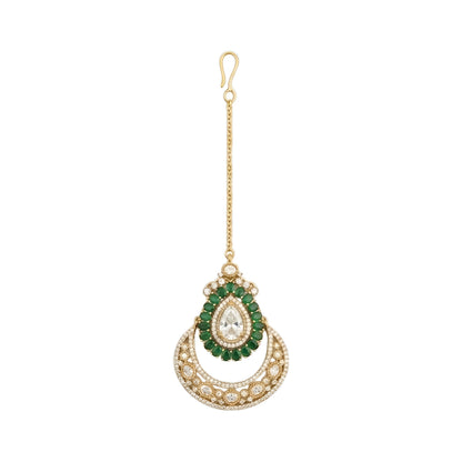 Elegant gold-plated bridal maang tikka featuring a pear-shaped crystal, green stones, and crescent crystal design for weddings and festive occasions.