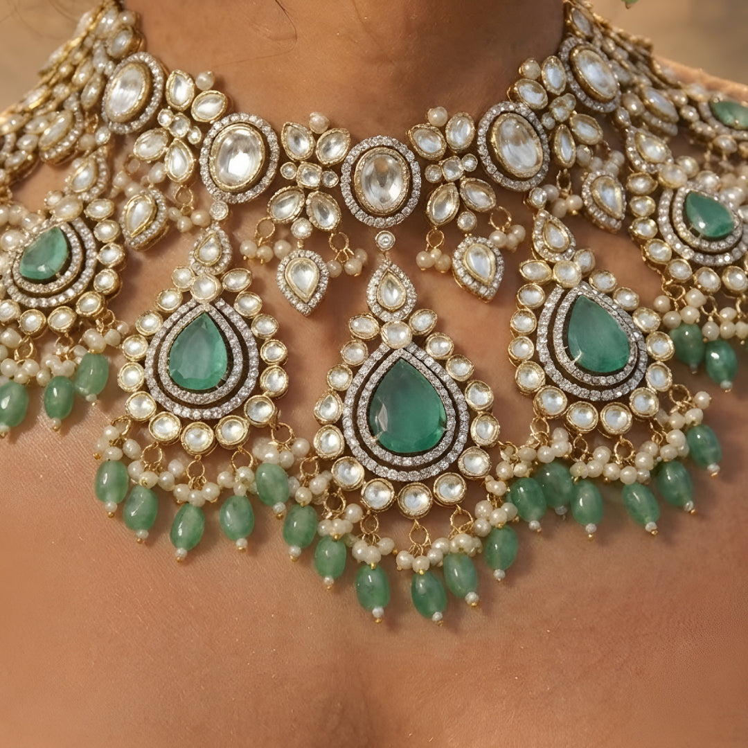 Luxury green Kundan bridal choker necklace set with matching earrings featuring white Kundan stones, green teardrop gemstones, and pearl bead detailing.