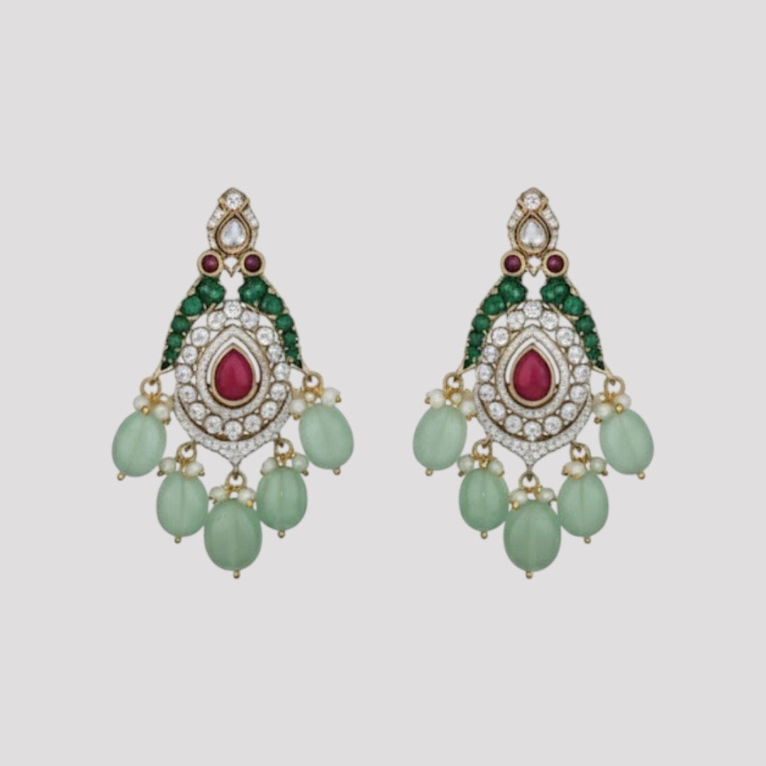 "Triple-layer gold-finish necklace set with ruby stones, green accents, AD detailing, pastel green bead drops, and matching earrings displayed on a light background."