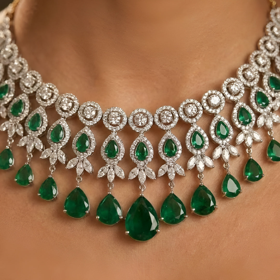 Silver-tone choker necklace and earrings set featuring sparkling clear crystals and emerald green teardrop stones in an elegant bridal jewelry design.