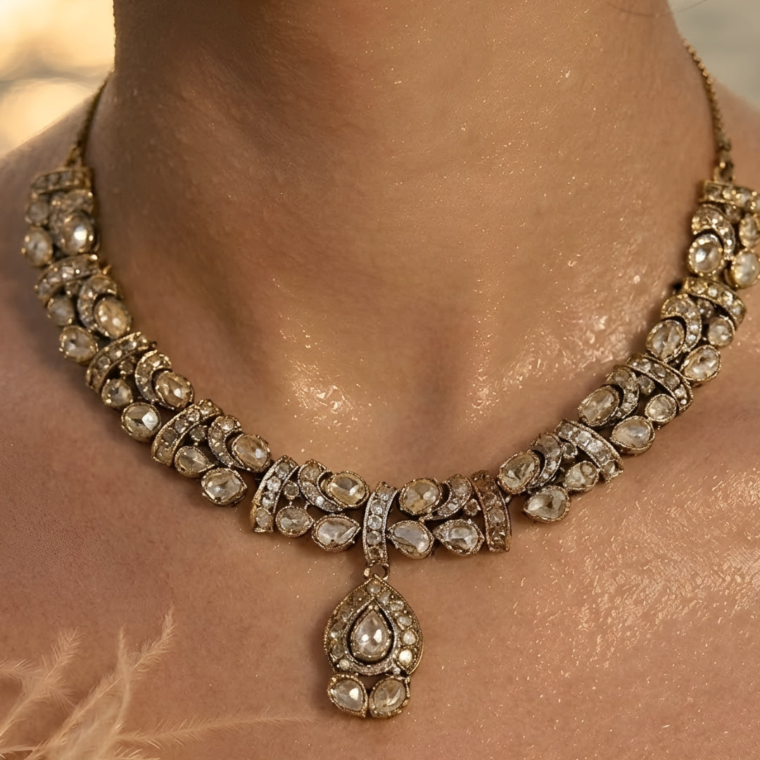 Gold-plated Kundan choker necklace set with matching drop earrings featuring teardrop stones and bridal-inspired traditional design.