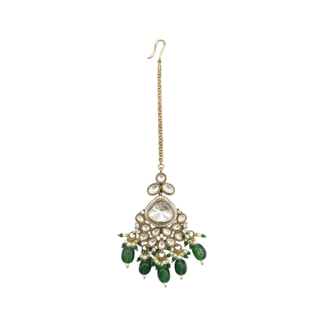 Gold plated Kundan maang tikka with white Polki stones, green bead drops, and pearl detailing for bridal wedding and festive wear.