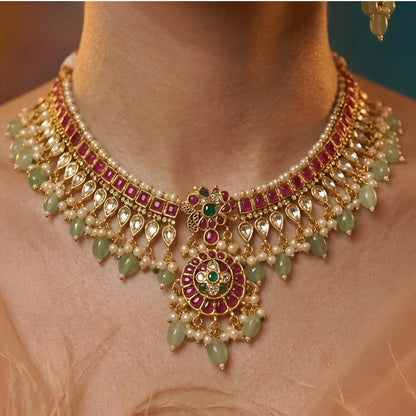 Traditional Kundan choker necklace set with ruby stones, green bead drops, gold finish, and matching earrings for bridal and wedding wear.