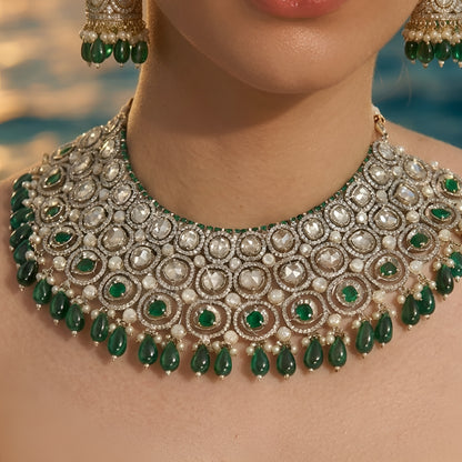 Traditional green Kundan choker necklace set with Polki stones, pearl detailing, green bead drops, and matching jhumka earrings for bridal and wedding wear.