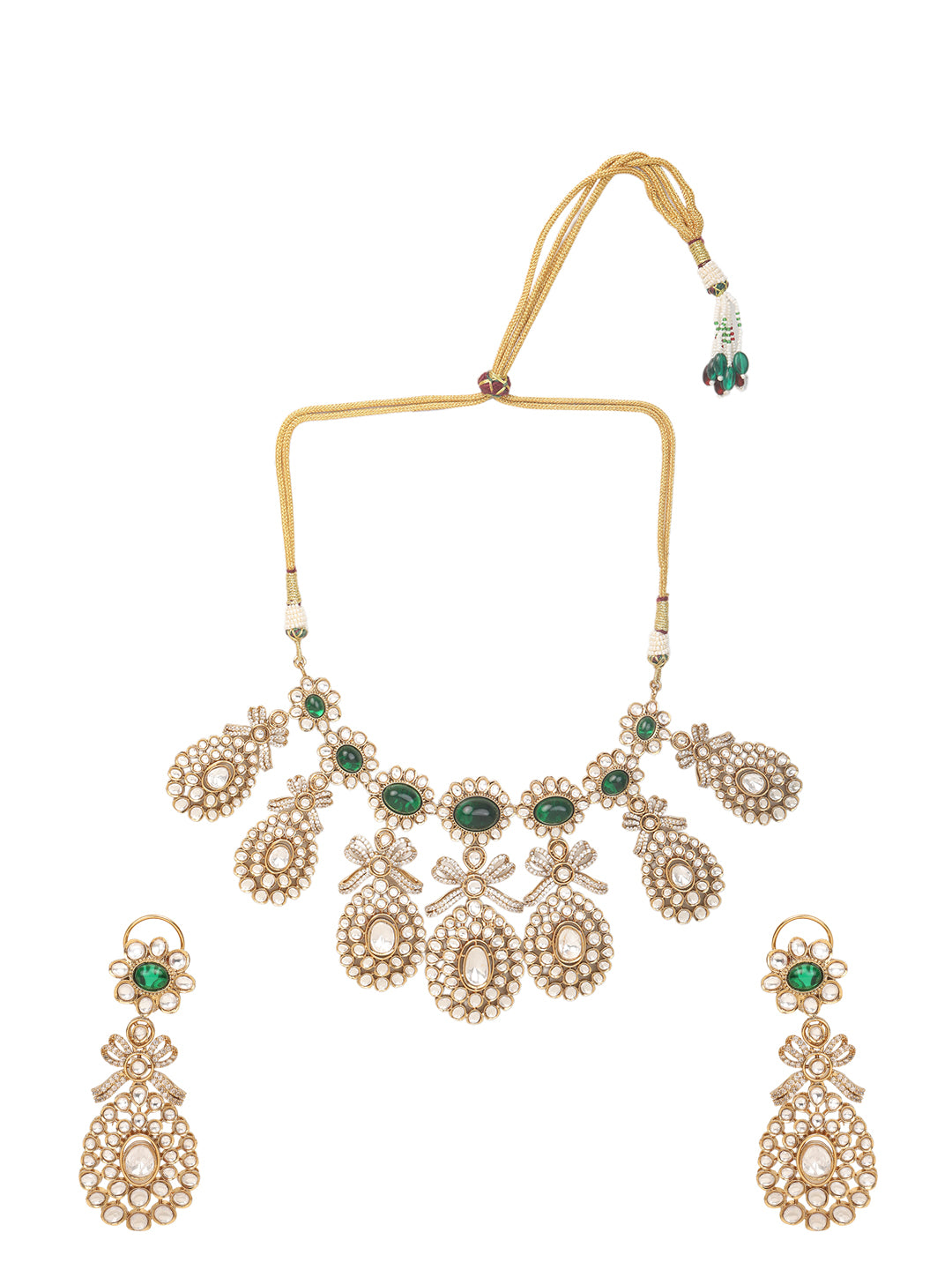 Gold-toned necklace with a braided cord and adjustable tassel tie, featuring intricate white stone detailing with oval green gemstones and multiple dangling teardrop motifs, paired with matching drop earrings, displayed on a plain light background.