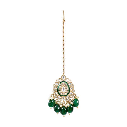 Gold-toned Kundan maang tikka with green enamel detailing, teardrop stones, pearl accents, and emerald-green bead drops for bridal and festive wear.