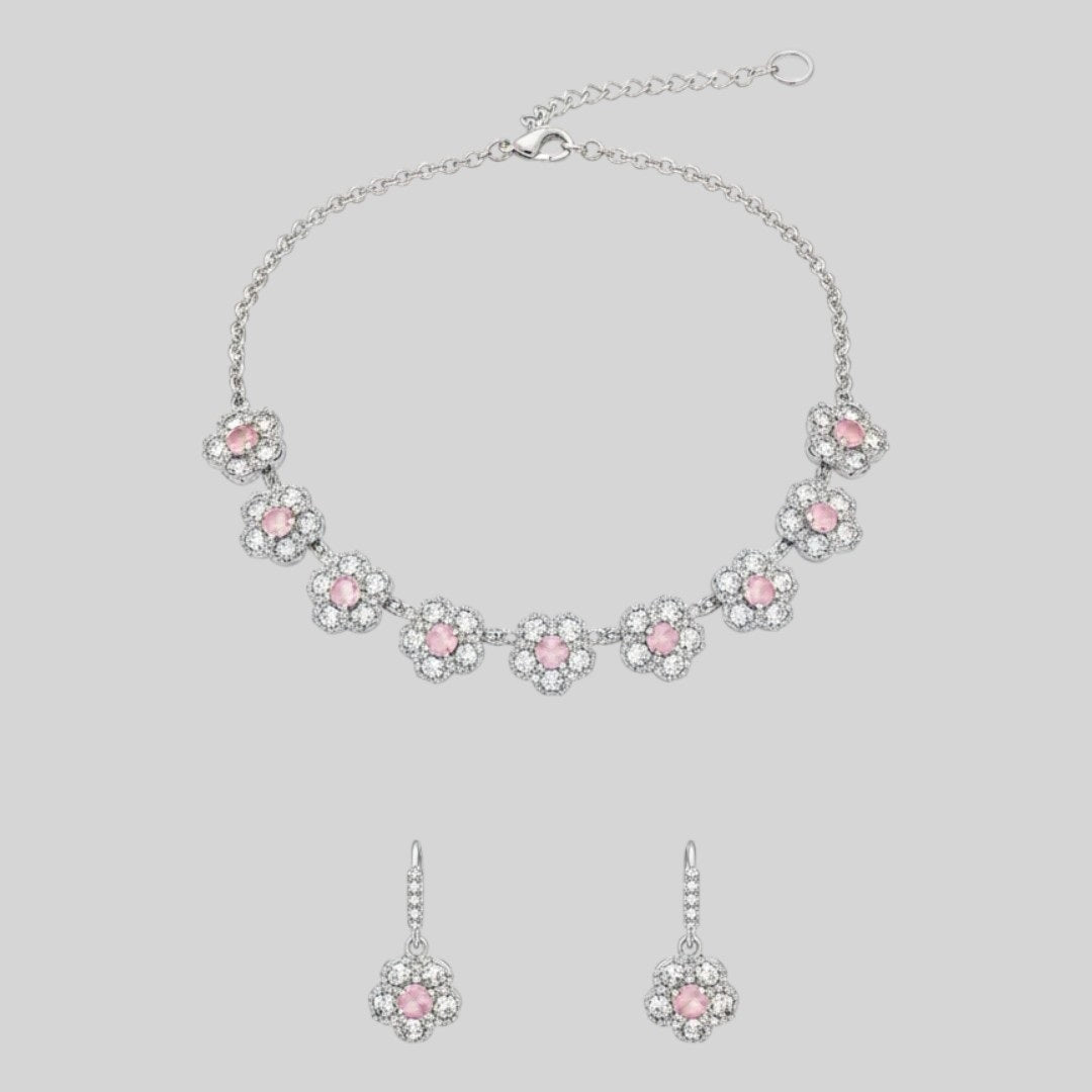 Silver floral necklace and matching earrings set with sparkling round crystals displayed on a red velvet jewelry stand, perfect for weddings and festive occasions.