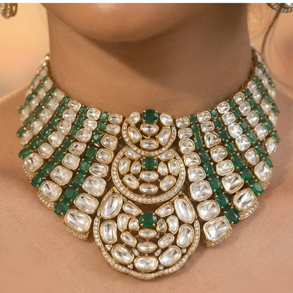 Luxury Kundan Polki necklace set with matching earrings featuring uncut Polki diamonds, green emerald accents, and traditional bridal jewelry craftsmanship in a gold finish.