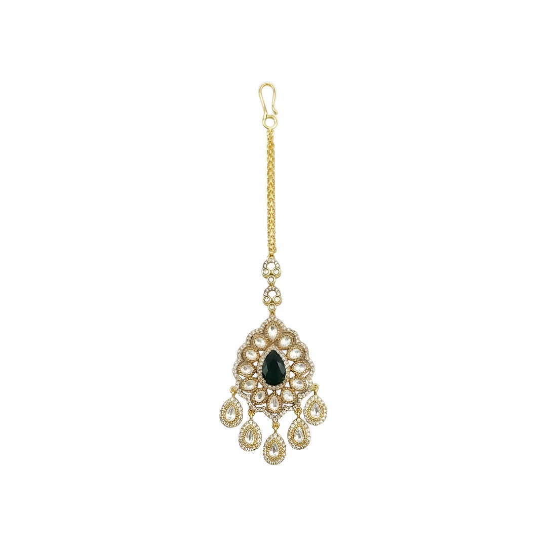 Gold-plated Kundan Maang Tikka with emerald green teardrop stone and white Kundan detailing for bridal and festive wear.