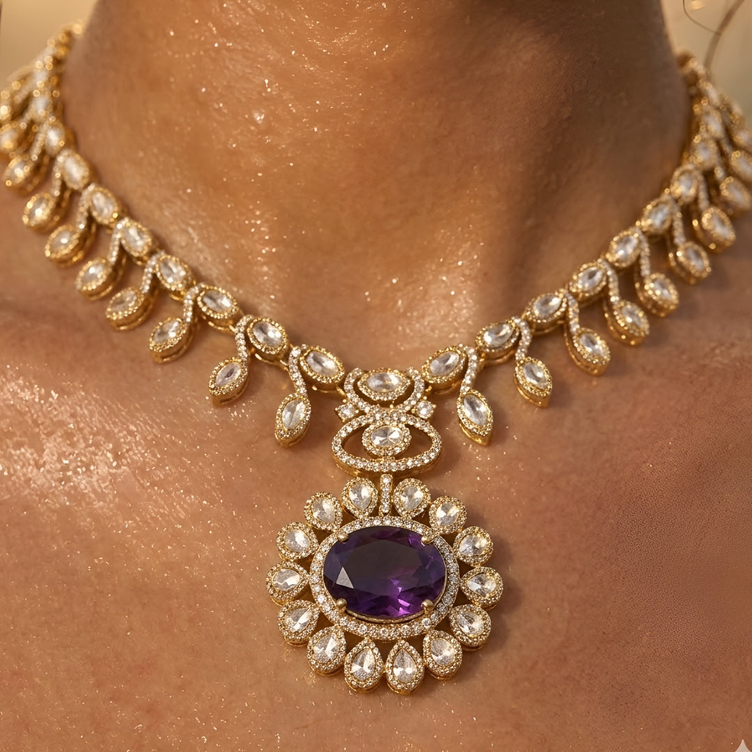 Gold-tone Kundan-inspired necklace and earrings set featuring white stones and deep purple oval gemstone accents in an elegant traditional design.
