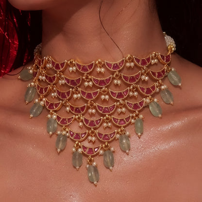 "Layered Kundan choker necklace and earring set in maroon gold with pearl and green bead drops, bridal jewellery styled on model"