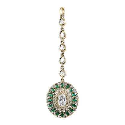 Gold-plated green American diamond bridal maang tikka with oval crystal centerpiece and green marquise stones on a white background.