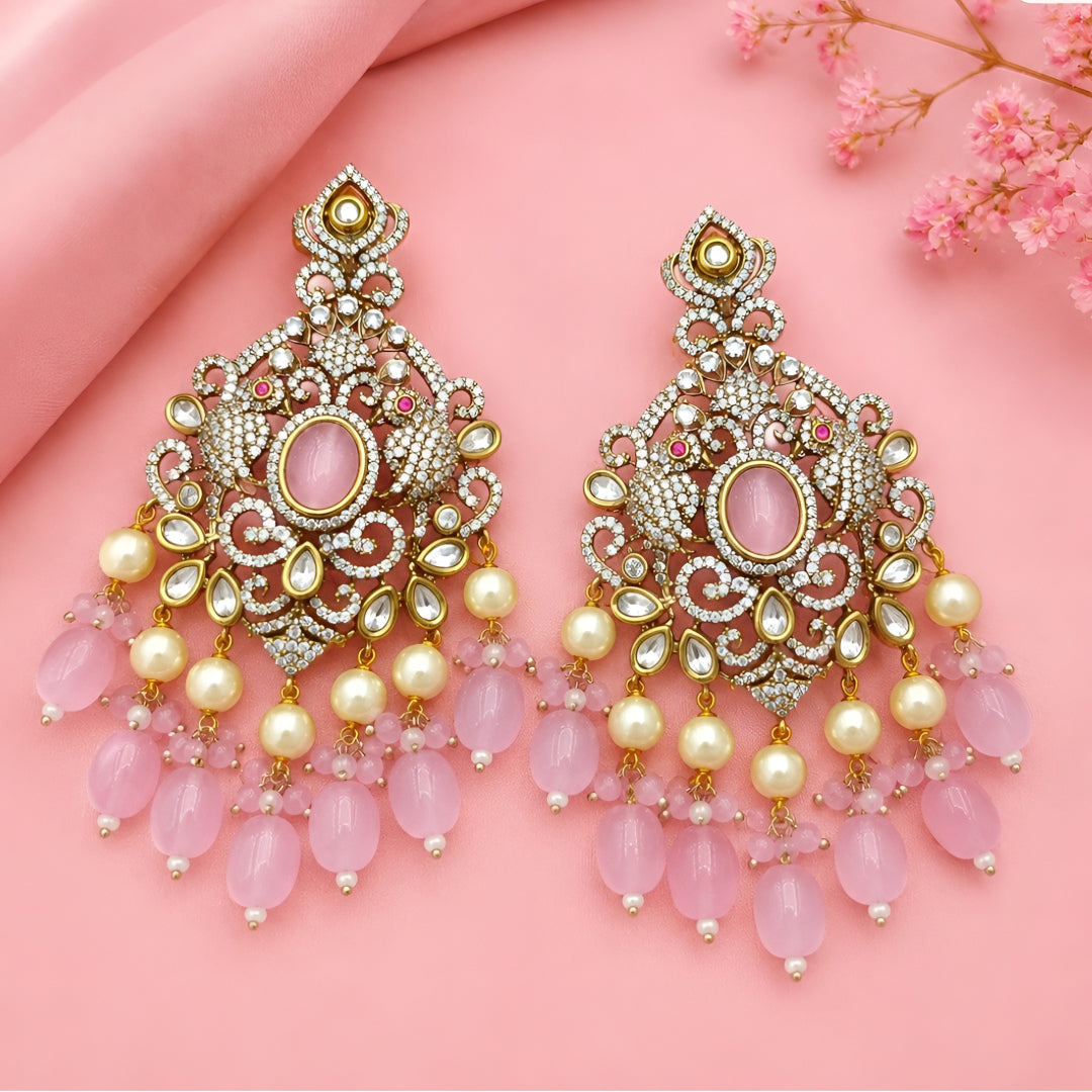 Pink Kundan Chandbali earrings featuring a blush pink center stone, sparkling Kundan detailing, pearl drops, and pink bead tassels with a gold-plated finish.