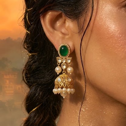 Gold-toned Navratna Kundan choker necklace set with multicolored stones, pearl drops, and matching green stone jhumka earrings on a white background.
