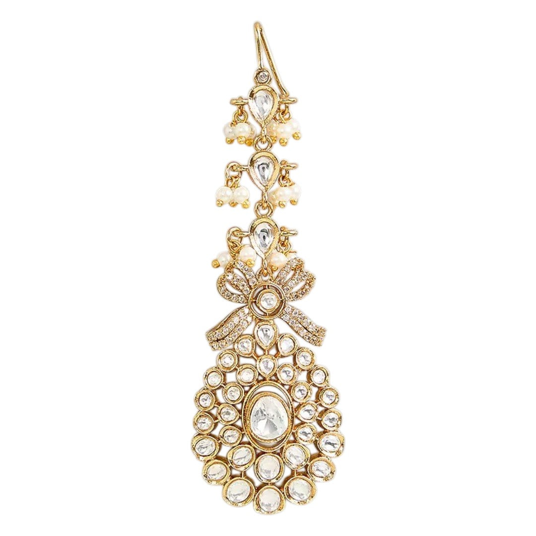 Gold-plated Kundan maang tikka with sparkling clear stones, pearl bead drops, and an elegant bridal design for weddings and festive wear.