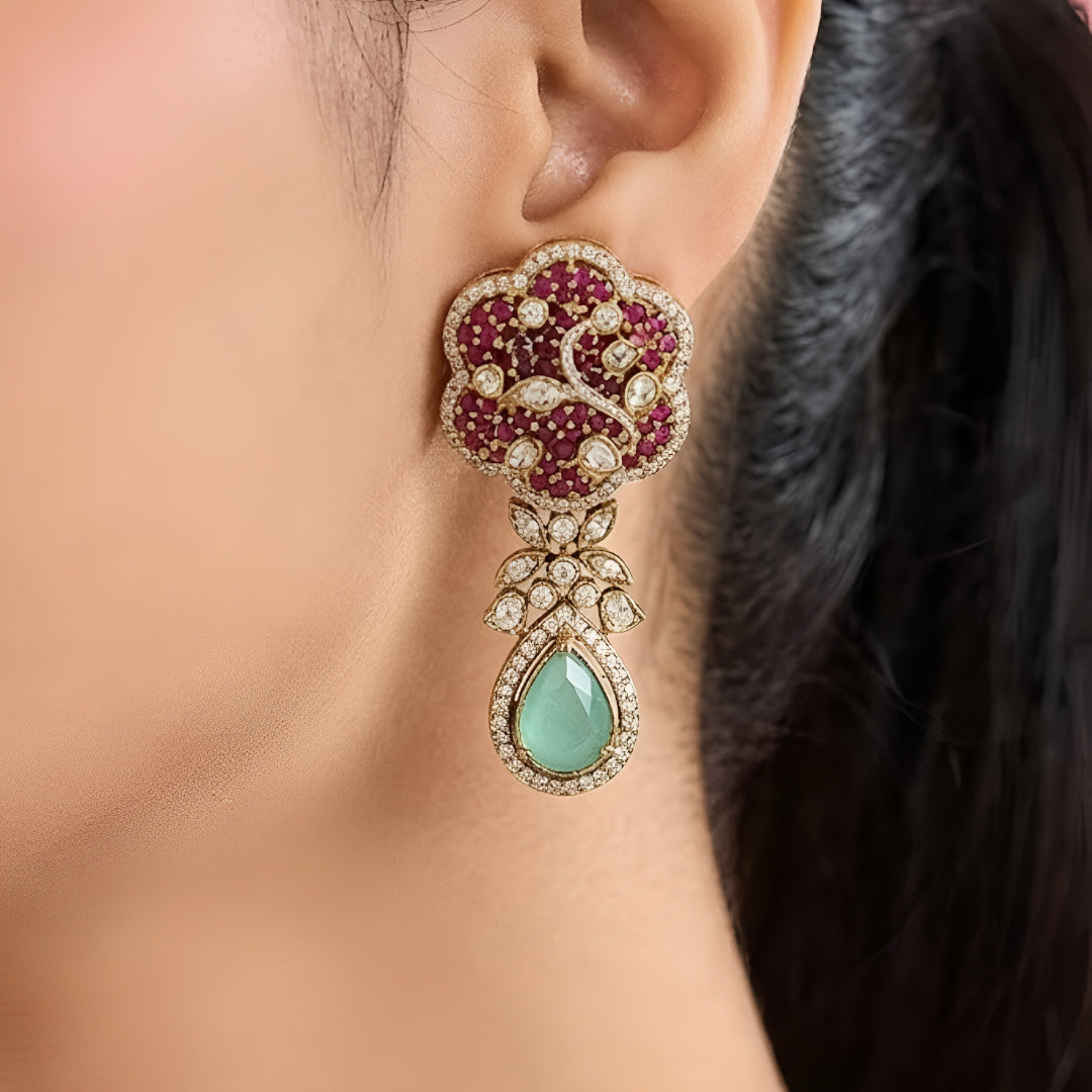 Designer ruby red kundan choker necklace set with sparkling crystal detailing, mint green teardrop gemstone centerpiece, and matching earrings for bridal and festive occasions.